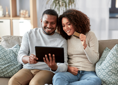 A couple sitting on the couch doing online shopping