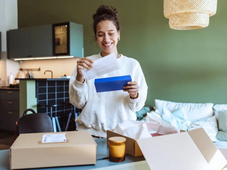 A happy woman is unboxing her subscription box delivery