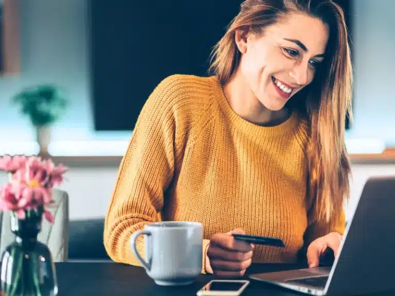 A woman paying something at her laptop