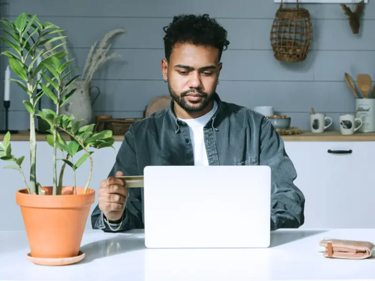 A man is shopping online in front of his laptop.