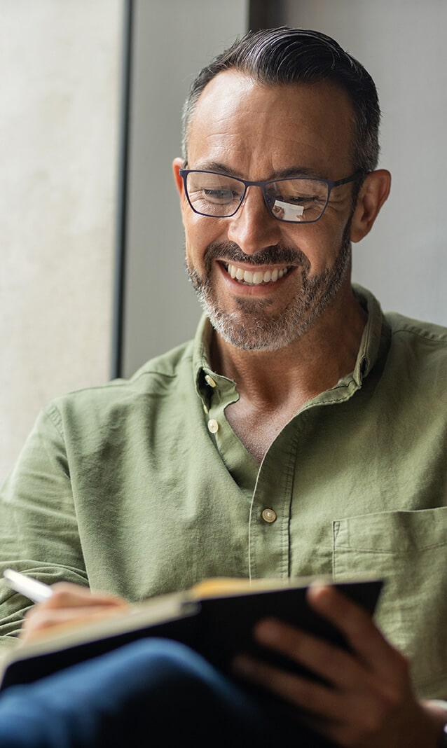 A man with glasses taking notes