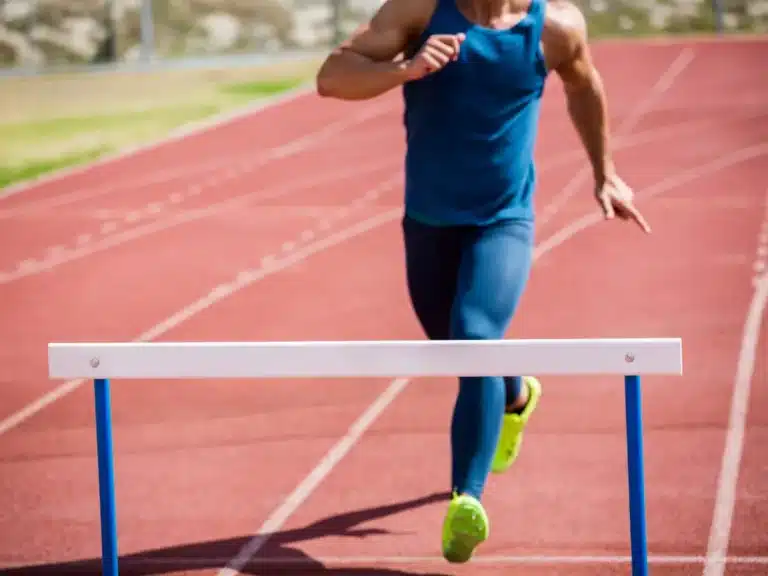 A runner approaches a hurdle.