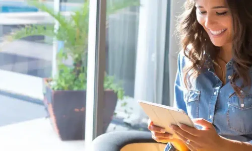 A woman is reading on a tablet.