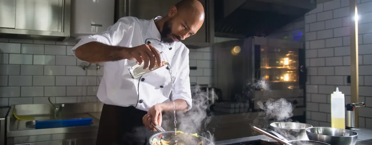 Success Story – Kanpla 1 A cook preparing a meal in his kitchen.