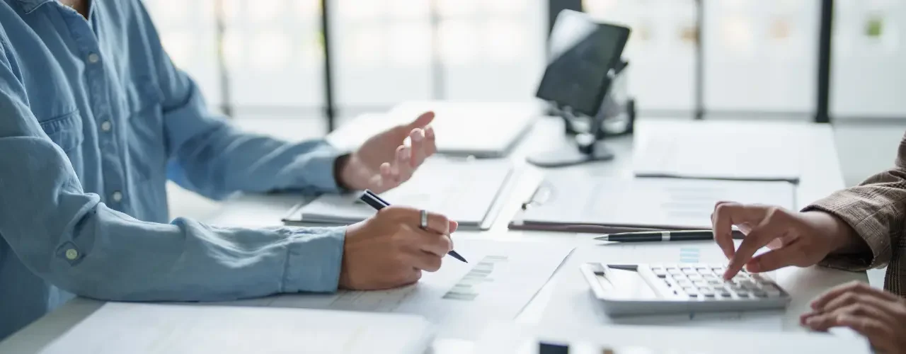 Two people sit at a table and discuss taxes