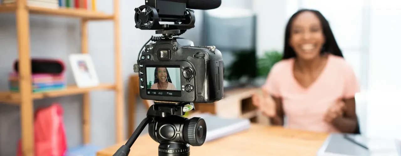 An influencer records herself, we can see her through her camera display.